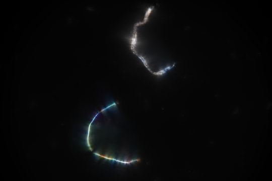 Two pieces of lint on a microscope slide catch and bend the light.